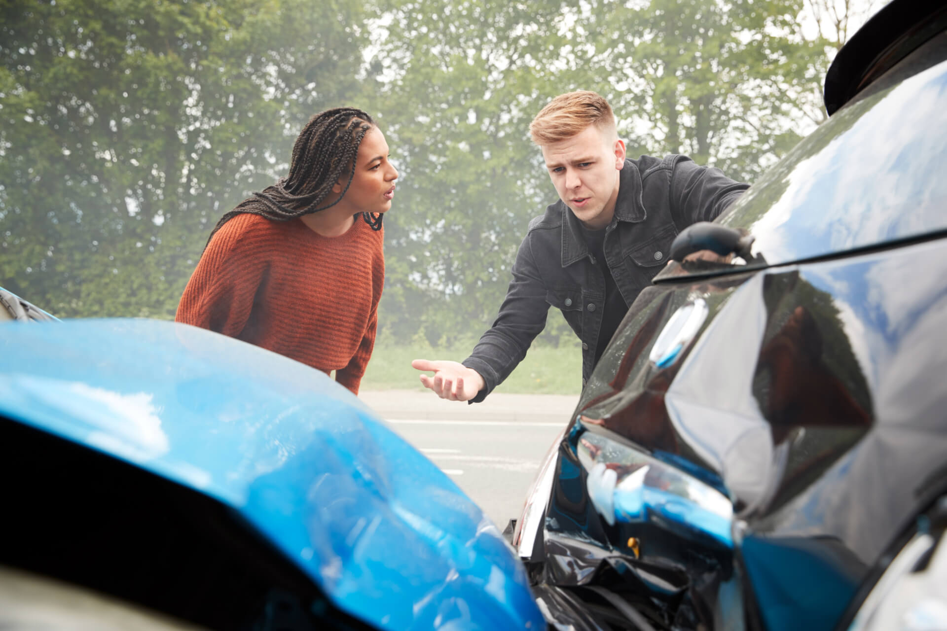 two angry motorists arguing over responsibility for a rear end accident