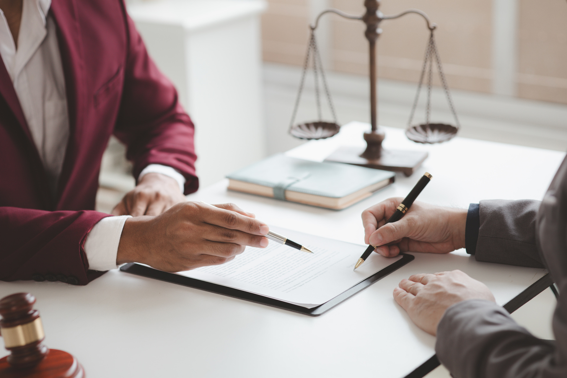 Two people review and sign legal contract