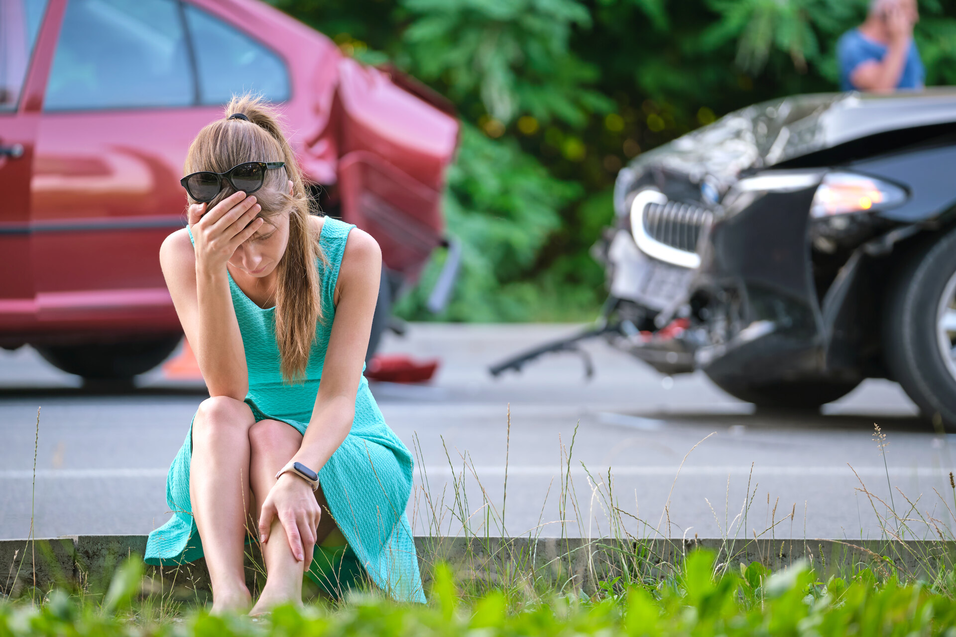 Woman sits distressed after car accident