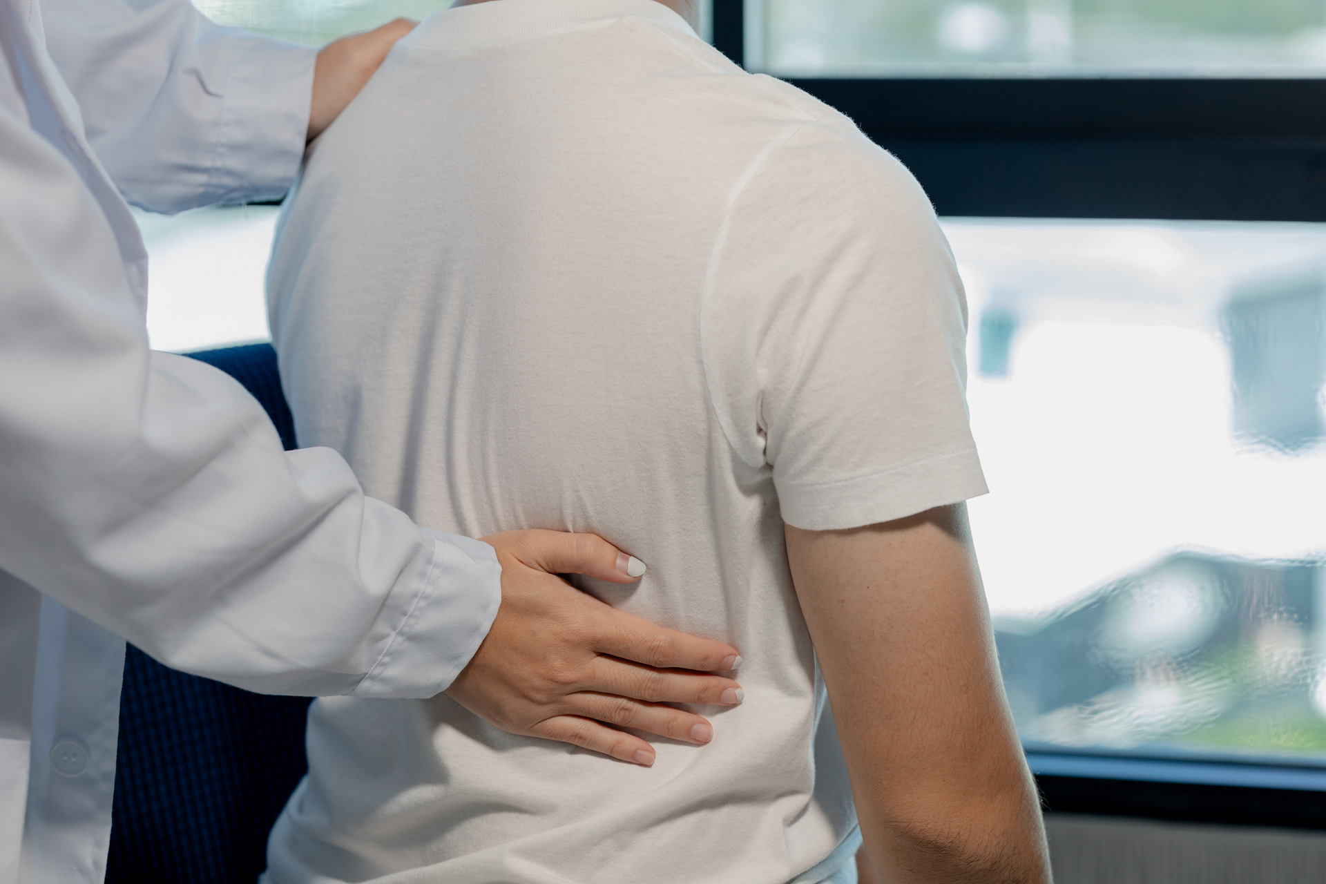 a physical therapist is helping a patient with back pain