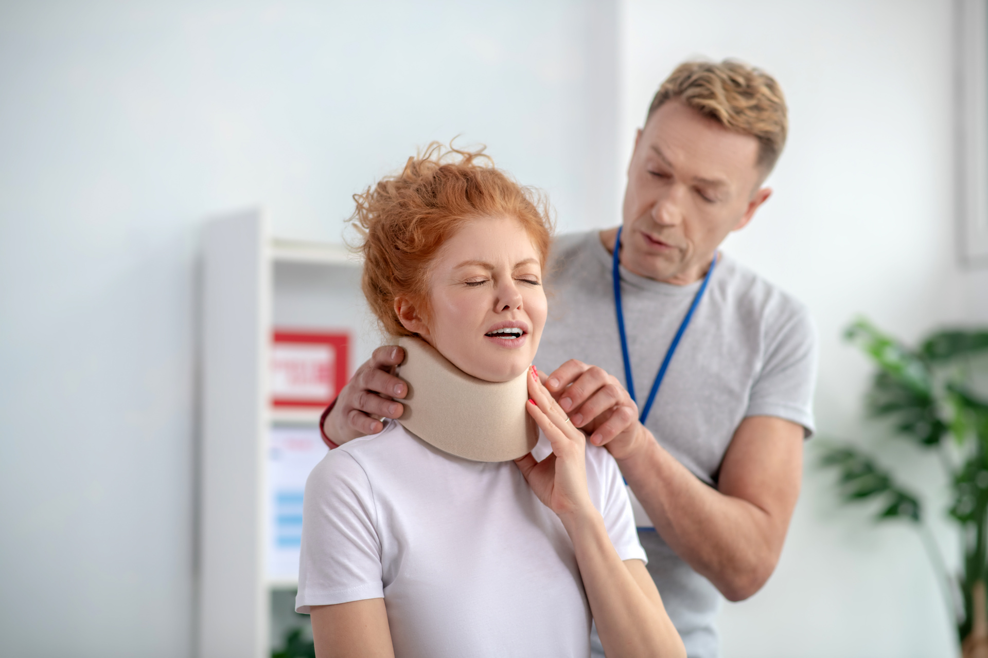 male physiotherapist examining neck fixator