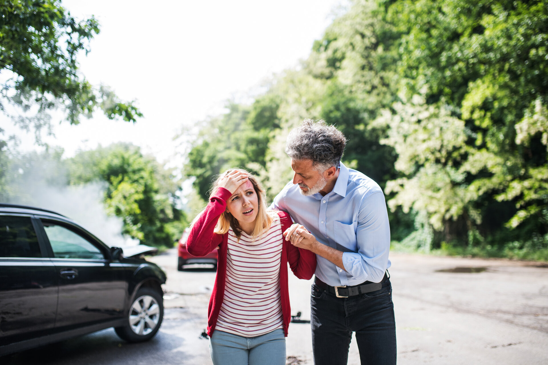 man helping a young woman after car accident