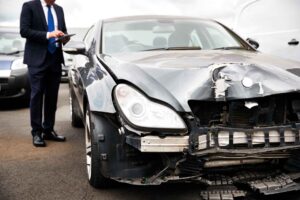 male lawyer with digital tablet standing next to a car