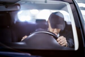 Impaired driver slumped over the steering wheel inside a vehicle, illustrating the dangers handled by Columbia Drunk Driving Accident Lawyers.